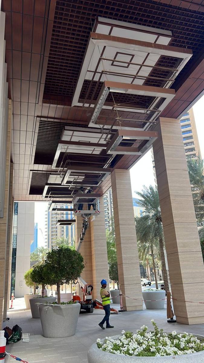 TechBee crew installing architectural pendant lighting from a boom lift